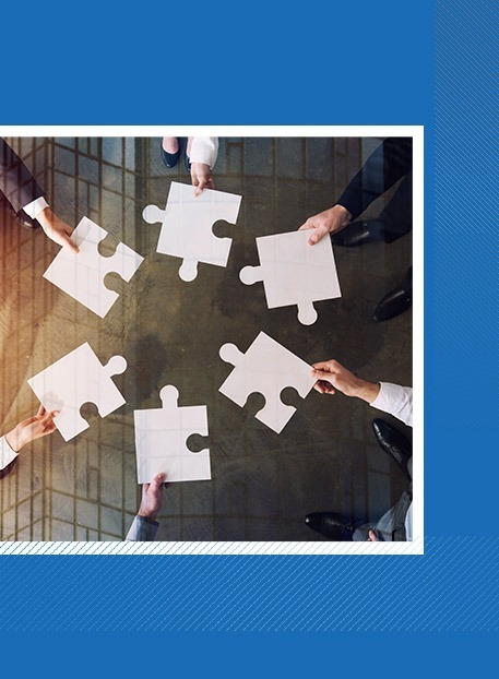 Business professionals holding puzzle pieces together